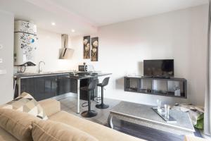 a kitchen and living room with a couch and a table at LU&CIA EL CARMEN in M&aacute;laga