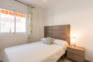 ein Schlafzimmer mit einem Bett und einem hölzernen Kopfteil in der Unterkunft LU&CIA LA CALA BEACH in La Cala del Moral