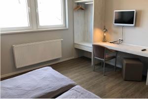 a bedroom with a desk with a computer and a bed at Haus Schönewald in Dormagen
