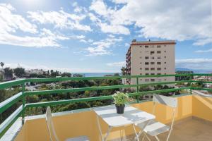 un balcón con mesa y sillas y un edificio en LU&CIA CANDADO BEACH RELAX, en Málaga