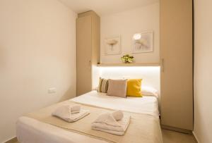 1 dormitorio con 1 cama con toallas en LU&CIA City Beach Puerto 1, en Málaga