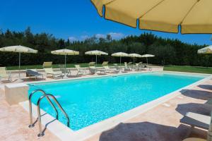 uma piscina com cadeiras e guarda-sóis em Il Casino di Remartello em Loreto Aprutino