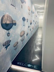 an escalator in a building with a mural of hot air balloons at MARGHERITA BOUTIQUE ROOMS in Margherita di Savoia