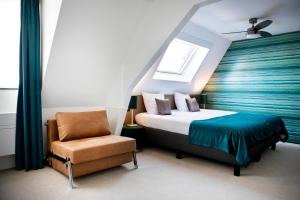 ein Schlafzimmer mit einem Bett, einem Stuhl und einem Fenster in der Unterkunft Hotel Amerika in Hoek van Holland