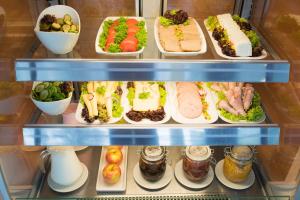 een koelkast gevuld met veel verschillende soorten voedsel bij Premiere Classe Wroclaw Centrum in Wrocław