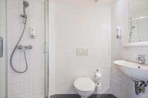 a bathroom with a shower and a toilet and a sink at Premiere Classe Wroclaw Centrum in Wrocław
