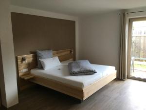 a bedroom with a bed with white sheets and a window at Gaestehaus Richter in Oberammergau