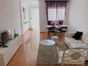 ein Wohnzimmer mit einem Sofa und einem Tisch in der Unterkunft APARTAMENTO CON TERRAZA 50M2，500M A LA PLAYA in Arenales del Sol