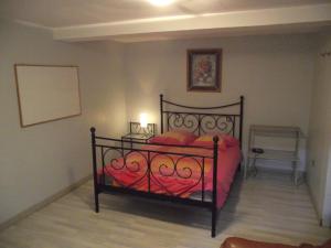 a bedroom with a bed with a red comforter at appartement dans le thouarsais in Thouars