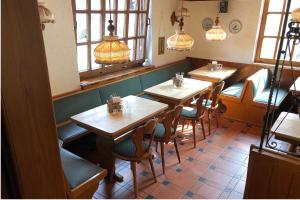 a restaurant with wooden tables and chairs and windows at Haus Schönewald in Dormagen