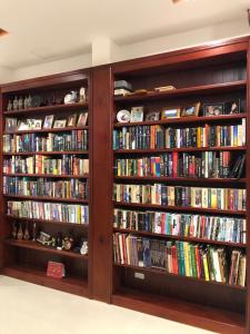 una biblioteca con estanterías de madera llenas de libros en Little Library Villa Hoi An en Hoi An