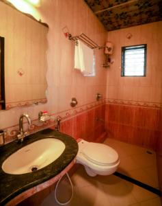 a bathroom with a sink and a toilet at Lucky Hotel Bandra in Mumbai