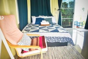 a bedroom with a bed and a chair and a window at Ban Ing Suan in Samutprakarn