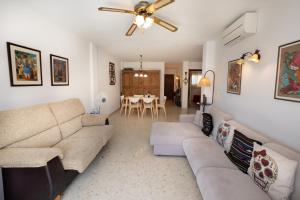 a living room with a couch and a ceiling fan at AGUAMARINA 7 MENYBER in Nerja