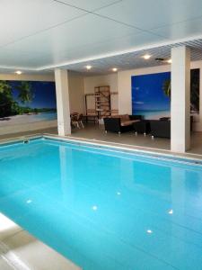 a large blue swimming pool in a hotel room at Fletcher Parkhotel Val Monte in Berg en Dal