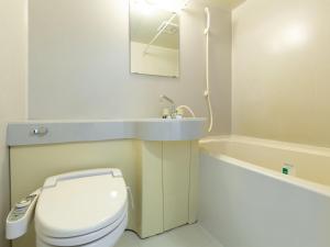 
a bathroom with a toilet a sink and a bathtub at APA Hotel Sendai Kotodai Koen in Sendai
