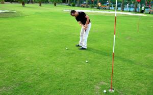 a man playing golf on a golf course at Camela Hotel & Resort in Hai Phong