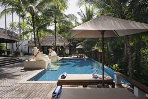 a swimming pool with a swan and an umbrella at Uma Giri Villas Ubud by GenuineHost in Ubud