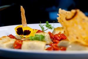 a plate of food with pasta and a flower on it at The Seymour Arms Blagdon in Blagdon