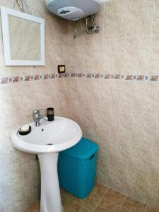 een badkamer met een witte wastafel en een spiegel bij Lovely Apt at the heart of the city&near the lake in Pogradec