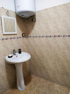 a bathroom with a white sink and a mirror at Lovely Apt at the heart of the city&near the lake in Pogradec +22 photos