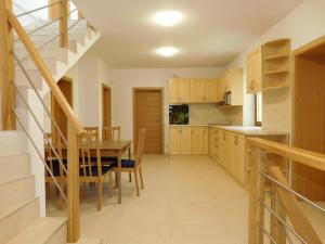 a kitchen and dining room with a table and a staircase at Villa Petko in Vysoke Tatry - Dolny Smokovec