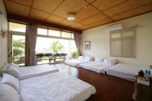 ein Zimmer mit einem Haufen weißer Betten darin in der Unterkunft Mama Tian Homestay in Xiaoliuqiu