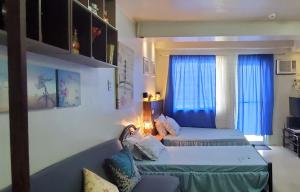ein Wohnzimmer mit 2 Betten und einem Sofa in der Unterkunft Jen's Apartment in Manila