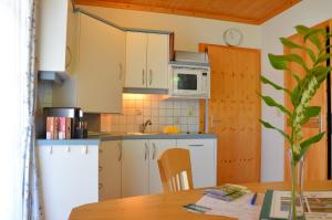 eine Küche mit weißen Schränken und einem Holztisch in der Unterkunft Ferienwohnungen Perhofer in Birkfeld