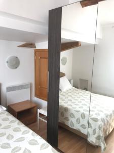 - une chambre avec un lit et un mur en verre dans l'établissement Studio du couvent, à Narbonne