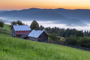 une ancienne grange assise sur une colline dans un champ dans l'établissement Casa De Vacanta Armi, à Molidu