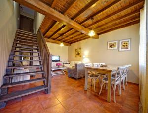 a living room with a wooden staircase and a table at Senderos del Jerte in Navaconcejo