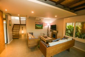 uma sala de estar com dois sofás e uma televisão em Pousada Boutique Villa Valley na Praia do Rosa