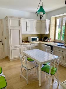 a kitchen with white cabinets and a table and chairs at Bouchardine - Centre - Parking gratuit - Hospices in Beaune