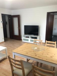 ノルトハイムにあるFerienwohnung An der Selde für 4 Personenの木製のテーブルとテレビのあるリビングルーム
