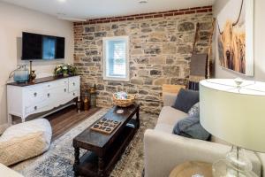 a living room with a stone wall at The McCrae House - Downtown Kingston in Kingston