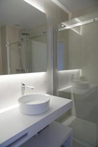 bagno bianco con lavandino e specchio di Stay In Apartments - D. Hugo 23 a Porto