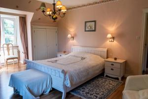 a bedroom with a white bed and a chandelier at B&B El Tyu in Écaussinnes-dʼEnghien