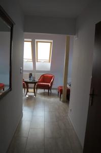 バルリネクにあるBukowa Przystań Barlinekのリビングルーム(赤い椅子、テーブル付)