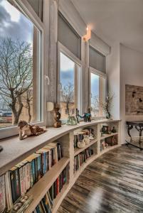 eine Bibliothek mit zwei großen Fenstern und Bücherregalen in der Unterkunft Luxury with sea view in Pula