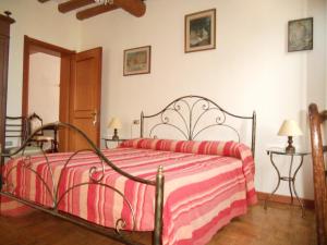 a bedroom with a bed with a red and pink blanket at Agriturismo Boaria Bassa in Castel dʼArio