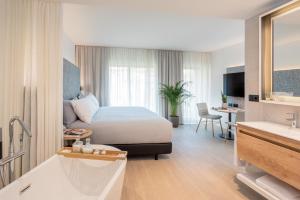 um quarto de hotel com uma cama e uma casa de banho em INNSiDE by Meliá Zaragoza em Saragoça
