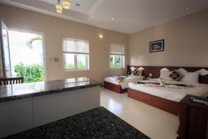 una camera d'albergo con due letti e una cucina di Mui Ne Volga Hotel & Apartments a Mui Ne
