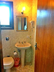 y baño con lavabo, aseo y espejo. en Pousada Palacio Monterei, en Campos do Jordão