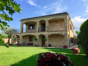 duży kamienny dom z balkonem na trawniku w obiekcie Villa con piscina in Abruzzo - A 7 minuti dal Mare w mieście Ripa Teatina