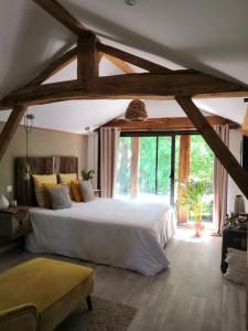 a bedroom with a large bed and a large window at Villa Rustique Le Carriou in Léon