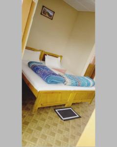 1 cama con marco de madera en una habitación en Nalgre Homestay, en Cherrapunji