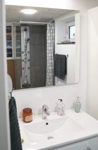 a bathroom with a white sink and a mirror at Romantic Klaksvik apartment in Klaksvík