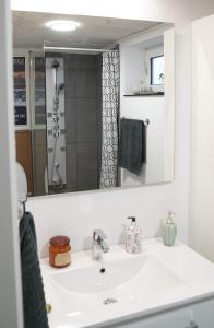 a bathroom with a white sink and a mirror at Romantic Klaksvik apartment in Klaksvík +12 photos