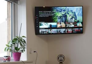 a flat screen tv hanging on a wall at Romantic Klaksvik apartment in Klaksvík